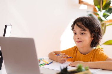 Çocuk evde video öğretmeniyle, evde, evde, uzaktan öğrenme, çevrimiçi eğitim, çevrimiçi ders alan çocuk, uzaklık eğitimi ve internet üzerinden öğrenim görüyor.