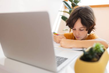 Çocuk evde video öğretmeniyle, evde, evde, uzaktan öğrenme, çevrimiçi eğitim, çevrimiçi ders alan çocuk, uzaklık eğitimi ve internet üzerinden öğrenim görüyor.