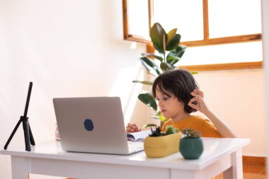 Çocuk evde video öğretmeniyle, evde, evde, uzaktan öğrenme, çevrimiçi eğitim, çevrimiçi ders alan çocuk, uzaklık eğitimi ve internet üzerinden öğrenim görüyor.