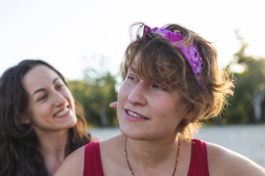 Kumsalda lezbiyen bir çift, iki kızın portresi, Igbt topluluğu, iki kadının ilişkisi, aşıklar, gülümseyen kızlar.