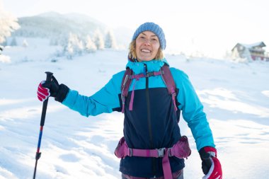 Kış yürüyüşünde sırt çantalı bir kadın, kış yürüyüşü, kar kaplı dağların arka planında bir kız.
