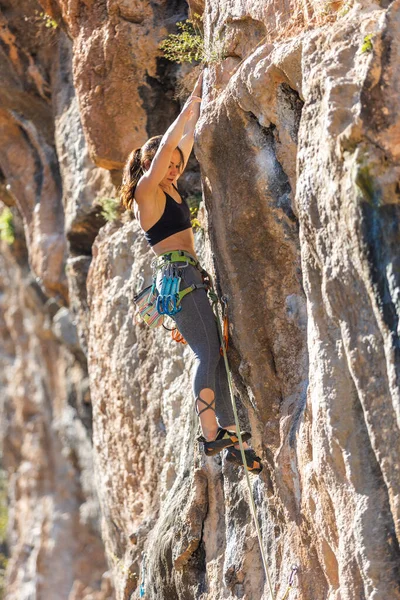 女が岩に登る 自然の地形での訓練 極端なスポーツだ 登山者は自然災害時に列車に乗る ロープを持つ若い女性は岩の上に登る岩のスポーツのために行きます — ストック写真