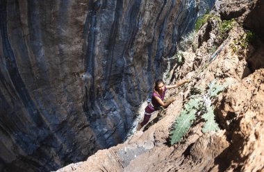 girl rock climber. a girl climbs a rock using equipment and a rope. active sports and outdoor recreation