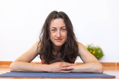 Kız mindere uzanıyor ve yoga yaptıktan sonra dinleniyor. Evde egzersiz..