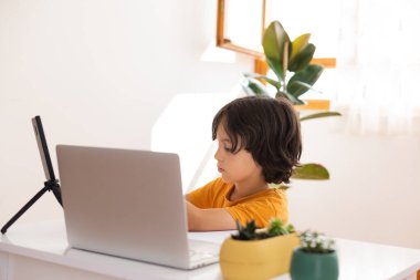 Çocuk evde video öğretmeniyle, evde, evde, uzaktan öğrenme, çevrimiçi eğitim, çevrimiçi ders alan çocuk, uzaklık eğitimi ve internet üzerinden öğrenim görüyor.