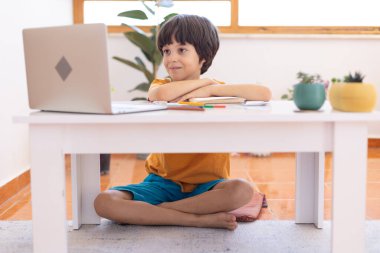 Online distance learning. a boy with a computer communicate via videoconference with a teacher and a class group. The child communicates online.