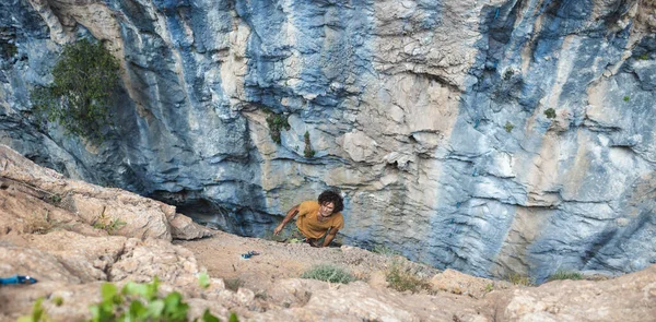 A strong man climbs a rock. Strong muscles. Endurance and strength training, man in extreme sport, Rock climber trains in nature.