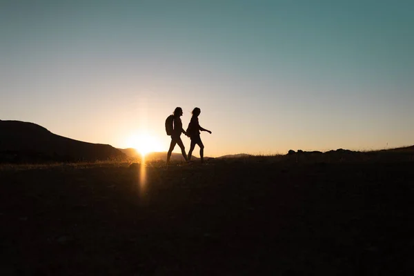 Silhouette Two Girls Backpacks While Traveling Mountains Sunset Two People — Foto de Stock