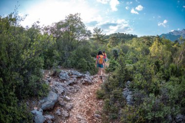 Sırt çantalı iki kız dağ yolunda yürüyorlar, güzel bir dağ ve gökyüzünün zeminine karşı kadınlar, dünyanın güzel yerlerinde bir yolculuk, Türkiye 'ye seyahat