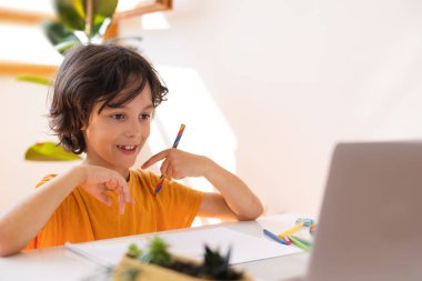 Çocuk evde video öğretmeniyle, evde, evde, uzaktan öğrenme, çevrimiçi eğitim, çevrimiçi ders alan çocuk, uzaklık eğitimi ve internet üzerinden öğrenim görüyor.