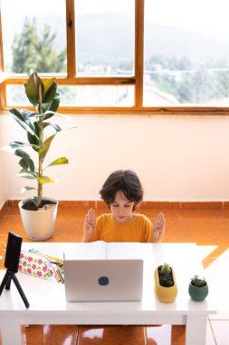 Çocuk evde video öğretmeniyle, evde, evde, uzaktan öğrenme, çevrimiçi eğitim, çevrimiçi ders alan çocuk, uzaklık eğitimi ve internet üzerinden öğrenim görüyor.