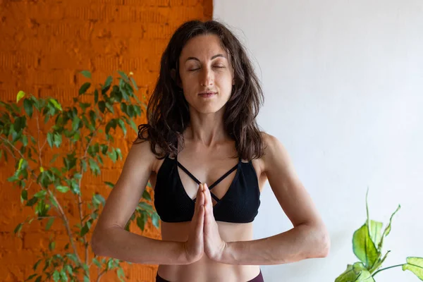 sağlıklı ve güzel vücut konsepti. Güzel esmer kadın meditasyon yapıyor, evde yoga yapıyor. Formda ve sağlıklı kalmak.