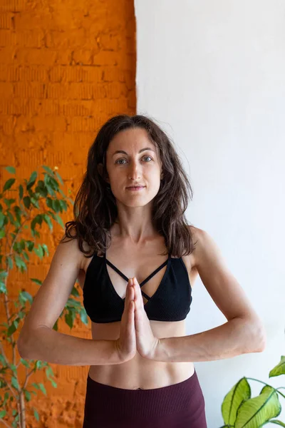 sağlıklı ve güzel vücut konsepti. Güzel esmer kadın meditasyon yapıyor, evde yoga yapıyor. Formda ve sağlıklı kalmak.