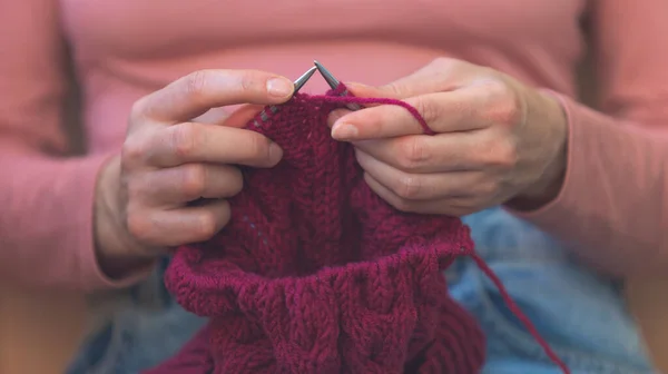 女性は編み物をしていて女性の手は近くにいて女性は針仕事に従事していて — ストック写真