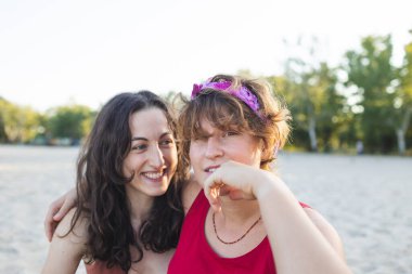 Kumsalda lezbiyen bir çift, iki kızın portresi, Igbt topluluğu, iki kadının ilişkisi, aşıklar, gülümseyen kızlar.