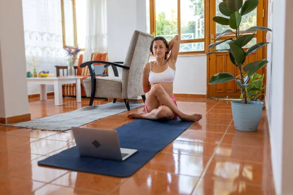girl doing yoga at home online, Young strong athletic fitness woman in pink tracksuit doing yoga