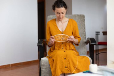 Kadın ipliklerden, ev dekorasyonundan, el yapımı tılsımlardan rüya yakalayıcı yapıyor.