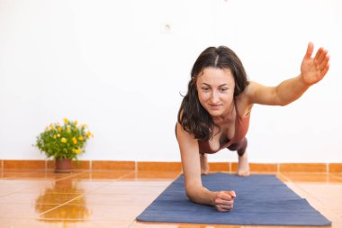 Kadın evde yoga yapıyor, zayıf kız egzersiz yapıyor, esneme egzersizleri yapıyor karın kası egzersizi yapıyor, karın kası egzersizi yapıyor.