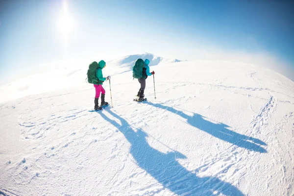 Dwie Kobiety Chodzą Śnieżnych Butach Zimą Trekking Dwie Osoby Górach — Zdjęcie stockowe