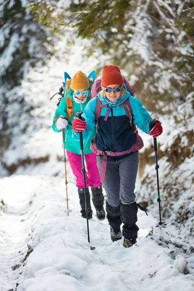 Zwei Mädchen Mit Rucksäcken Laufen Durch Den Schnee Zwischen Den — Stockfoto