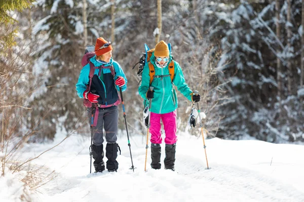 Dvě Dívky Batohy Procházejí Sněhem Mezi Stromy Zimní Turistika Horách — Stock fotografie