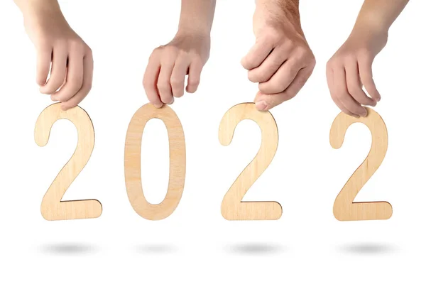 2022 nolu kontrplak numaralarını tutan bir ailenin elleri beyaz üzerinde izole edilmiş. — Stok fotoğraf