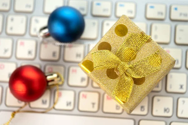 Christmas balls and a gift box on the computer keyboard Stock Photo