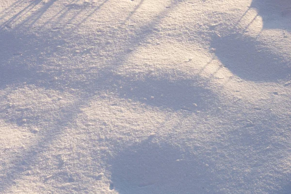 Background with a fragment of an uneven snow surface with pits and shadows — Stock fotografie