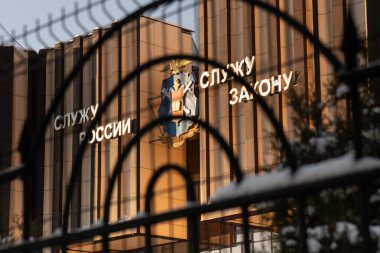 Moscow, Russia-January 7, 2022. Emblem and slogan I serve Russia I serve the law on a facade of a police college behind a metallic grid in Moscow in winter day