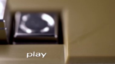 Parmak, eski bir teyp kaydedicisinin çalma tuşuna basar