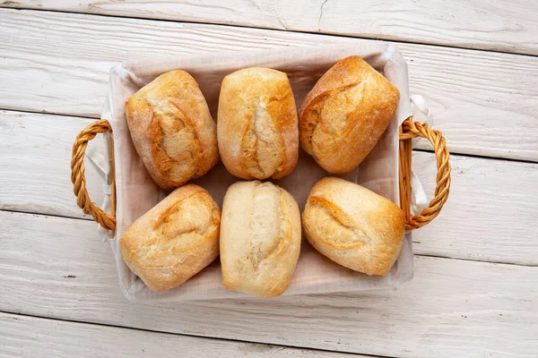 Smaczny Świeży Chleb Pszenny Wiklinowym Koszu Białym Drewnianym Stole Smaczne — Zdjęcie stockowe