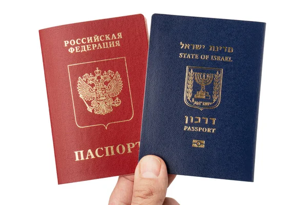 Beyaz arka planda İsrail ve Rusya 'nın uluslararası seyahat pasaportları erkek elinde.. — Stok fotoğraf