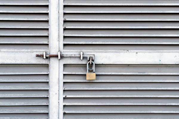 閉じた金属製のドアにぶら下がっている小さな南京錠 — ストック写真