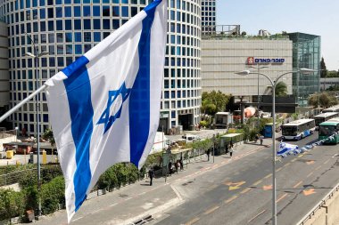 Tel Aviv, İsrail - 9 Mayıs 2022: İsrail bayrağı Tel Aviv caddesi önünde, modern yüksek binaların önünde Davut 'un yıldızı