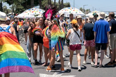 Tel Aviv Yafo, İsrail - 10 Haziran 2022. Neşeli gülümseyen kızlar ellerinde lgbt bayrakları ve gay onur geçidinde poz veren diğer lgbt özellikleri