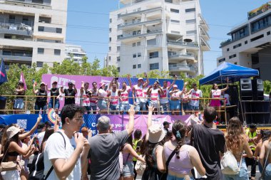 Tel Aviv Yafo, İsrail - 10 Haziran 2022. İnsanlar gay onur yürüyüşünde büyük bir lgbt bayrağı taşıyor.
