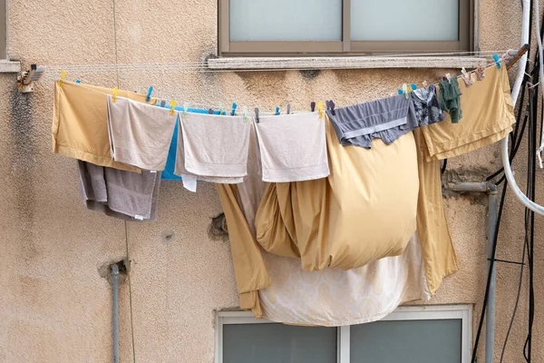 Bed linen,clothes, towels are dried on a rope and swaying in the wind outside the window in the street in Israel