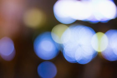 Odak dışı mavi ve sarı ışıkları olan soyut arkaplan bir bokeh etkisi yaratıyor.