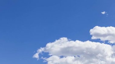 Accelerated sequence of blue sky through which white clouds pass from left to right.
