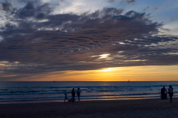 Gün batımında sahilde aile yürüyüş