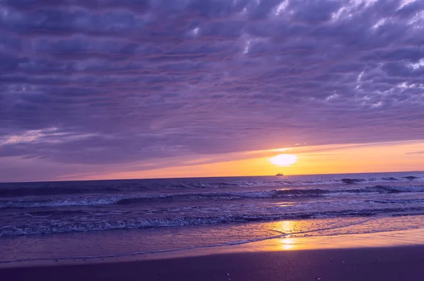 Denizde sıcak gün batımı. Ufukta bir geminin silueti görünüyor. Günbatımında Anapa, Karadeniz, Krasnodar Krai, Rusya 'da dramatik bulutlu gökyüzü ile güzel manzara