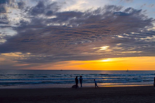 Gün batımında sahilde aile yürüyüş