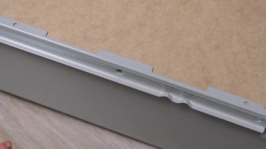 Beyaz kadın elektrikli matkapla cıvata ya da dolap çekmecesinin vidasını takıyor. Evde vida tabancasıyla mobilya monte etmek