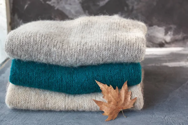 Montón Suéteres Punto Con Una Hoja Aislada Sobre Fondo Gris —  Fotos de Stock