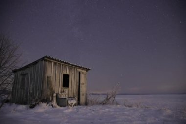 Gece Gökyüzü Yıldızı Kırsal kesimde kışın kalabalık bir Küçük Ev 'in önünde.
