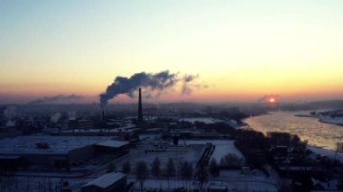 Şehrin çevresindeki hava panoramik uçuşu. Kış karbondioksit emisyonları, duman ve buhar enerjisi, güneş duman bulutları arasında parlar. Doğanın ekolojisi ve kirliliği.