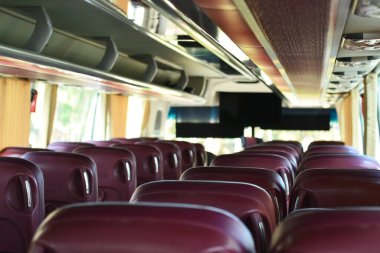 Sıra sıra koltukları olan bir turist otobüsünün içi boş.
