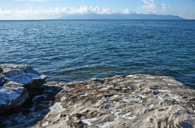 Güneşli bir günde kayalık adadan anakaraya manzara