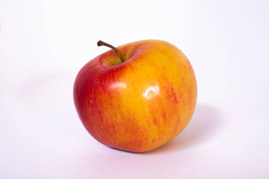 Elma beyaz arkaplanlı ve gölgeli.