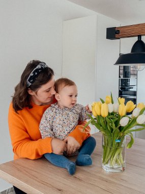 Mutfakta bebeği olan genç bir anne.